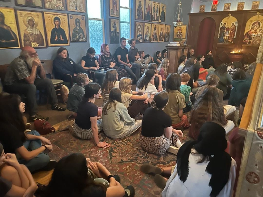 Youth seated in a church listening to a speaker